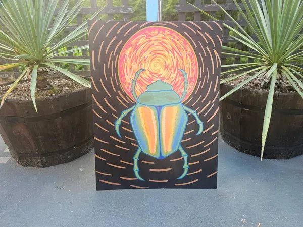 A luminous teal beetle against a dark background with a swirling orange sun halo